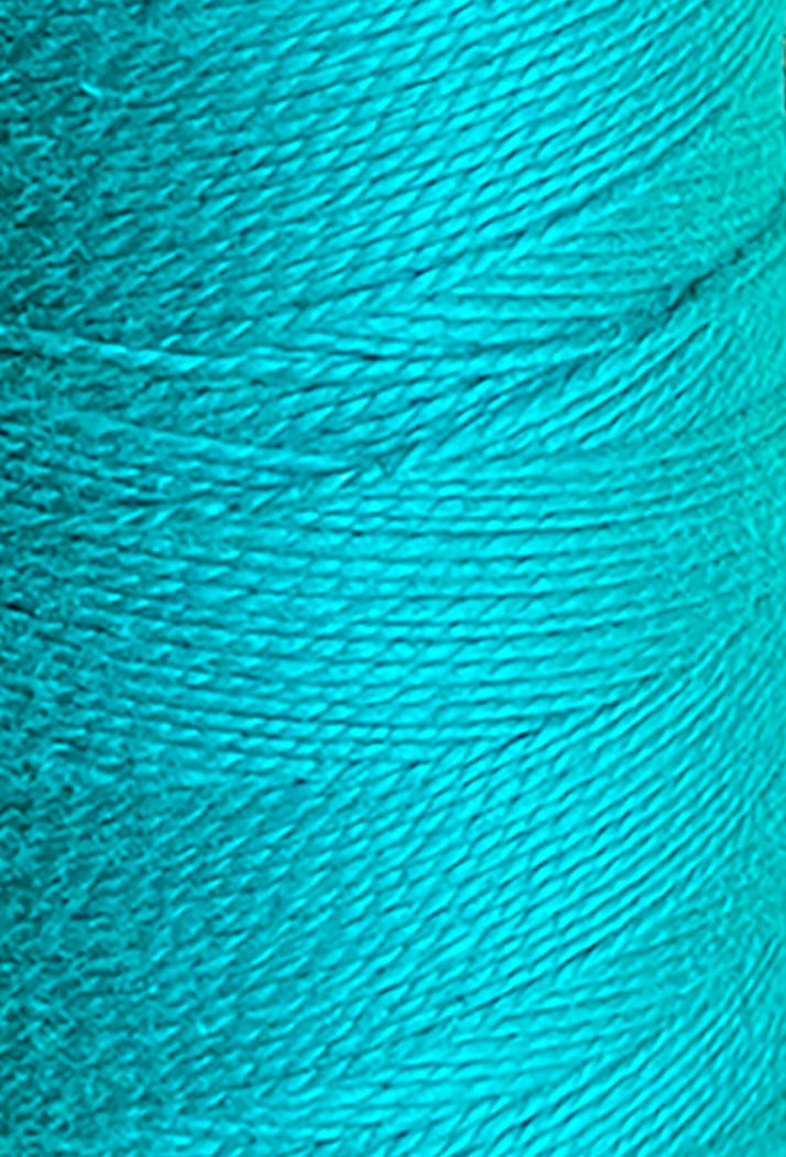 Close-up of Circulo's 10/2 Looma Circulo Mercerized Pearl Cotton Yarn in turquoise blue, tightly wound on a mini cone to highlight the fine texture and fibers of the mercerized thread.