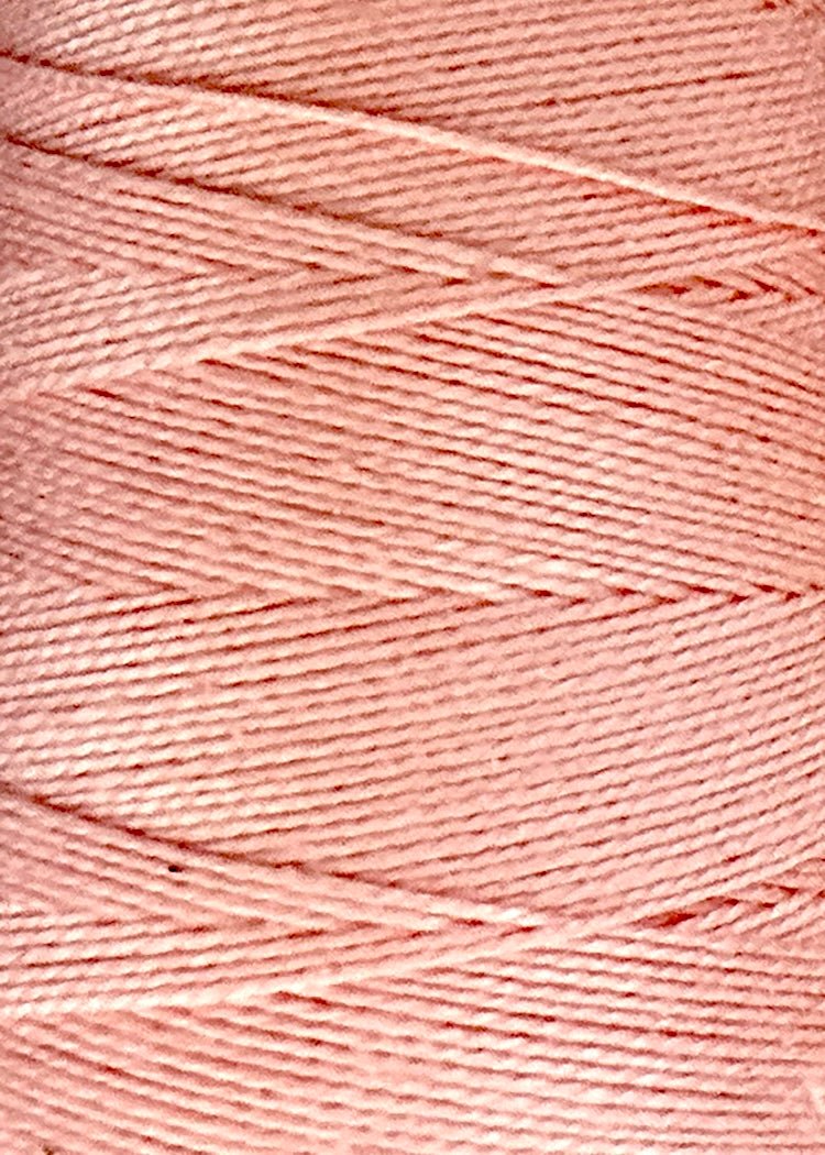 A close-up of light pink 5/2 Looma Circulo Mercerized Pearl Cotton Yarn wound tightly on a mini cone, showcasing its smooth, glossy texture and neatly layered strands from the Circulo brand.