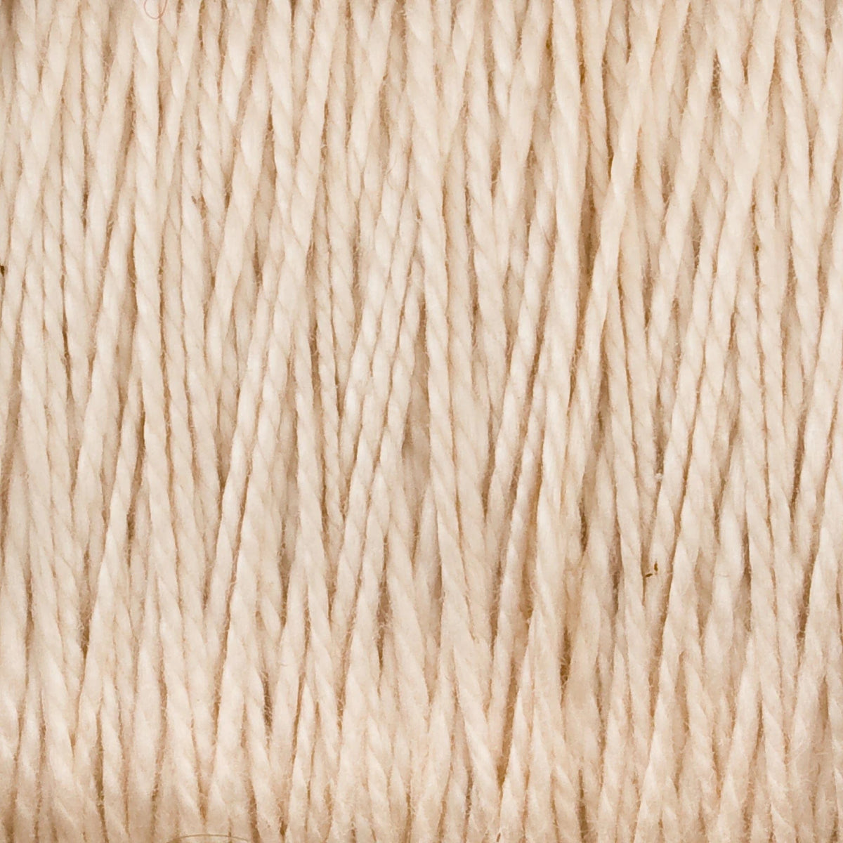 Close-up of Supreme Corp. 5/2 Pearl Cotton Yarn | Large Cone in beige or off-white, featuring tightly wound, parallel fibers with a slightly rough texture.