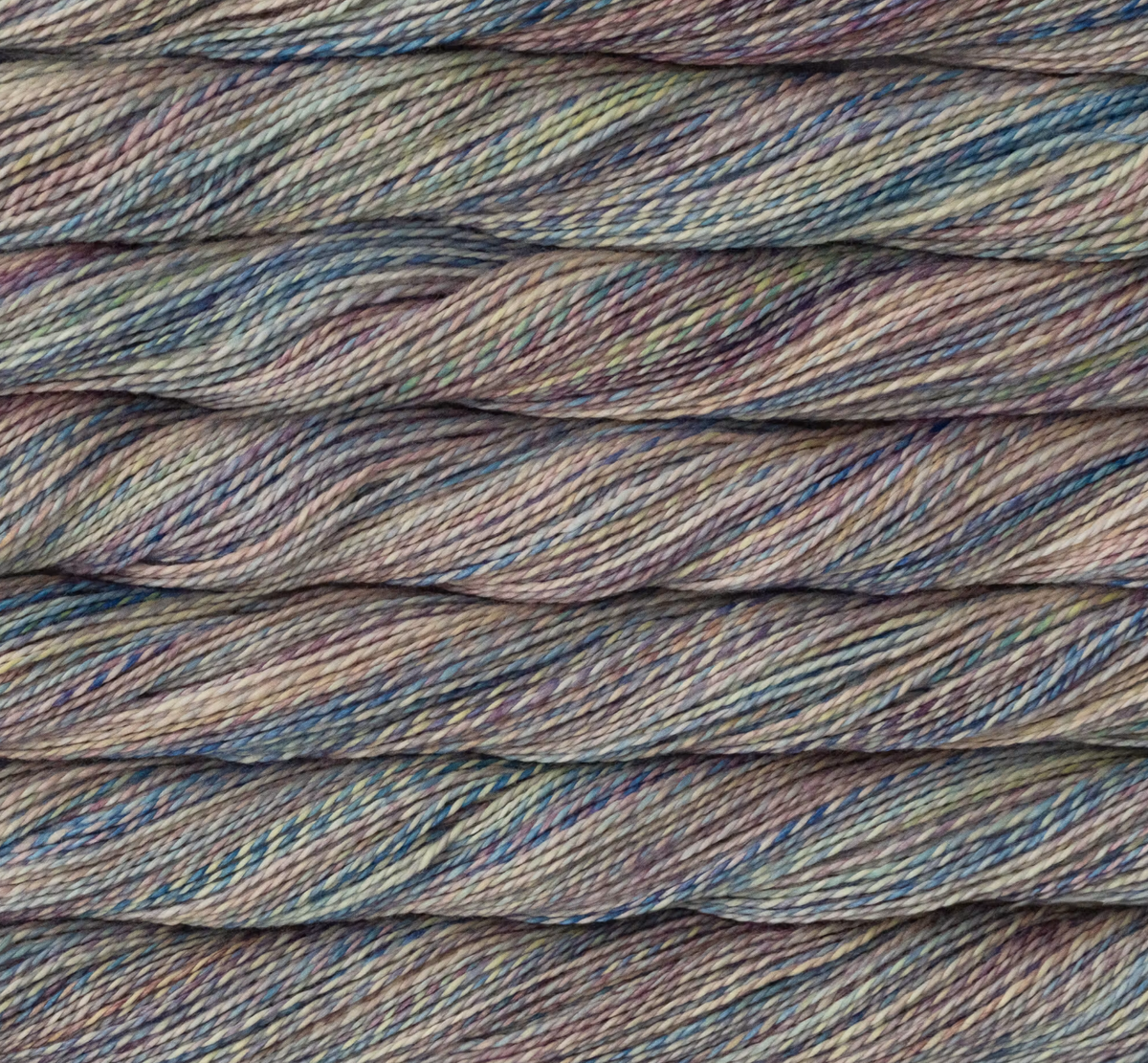 Close-up of Malabrigo Torzal sport weight yarn in variegated shades of blue, purple, and tan.