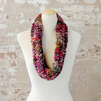 A thick, chunky knit Veinte Cowl Pattern by Kirsten Hipsky in multicolored Malabrigo Caracol yarn worn on a mannequin.