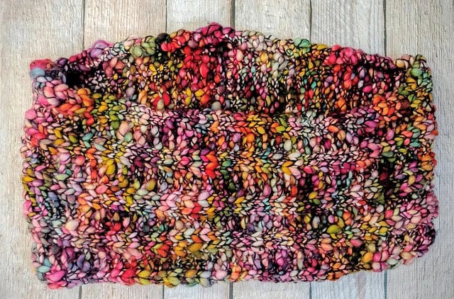 A Veinte Cowl Pattern cowl knit with thick, multi-colored variegated Malabrigo Caracol yarn.