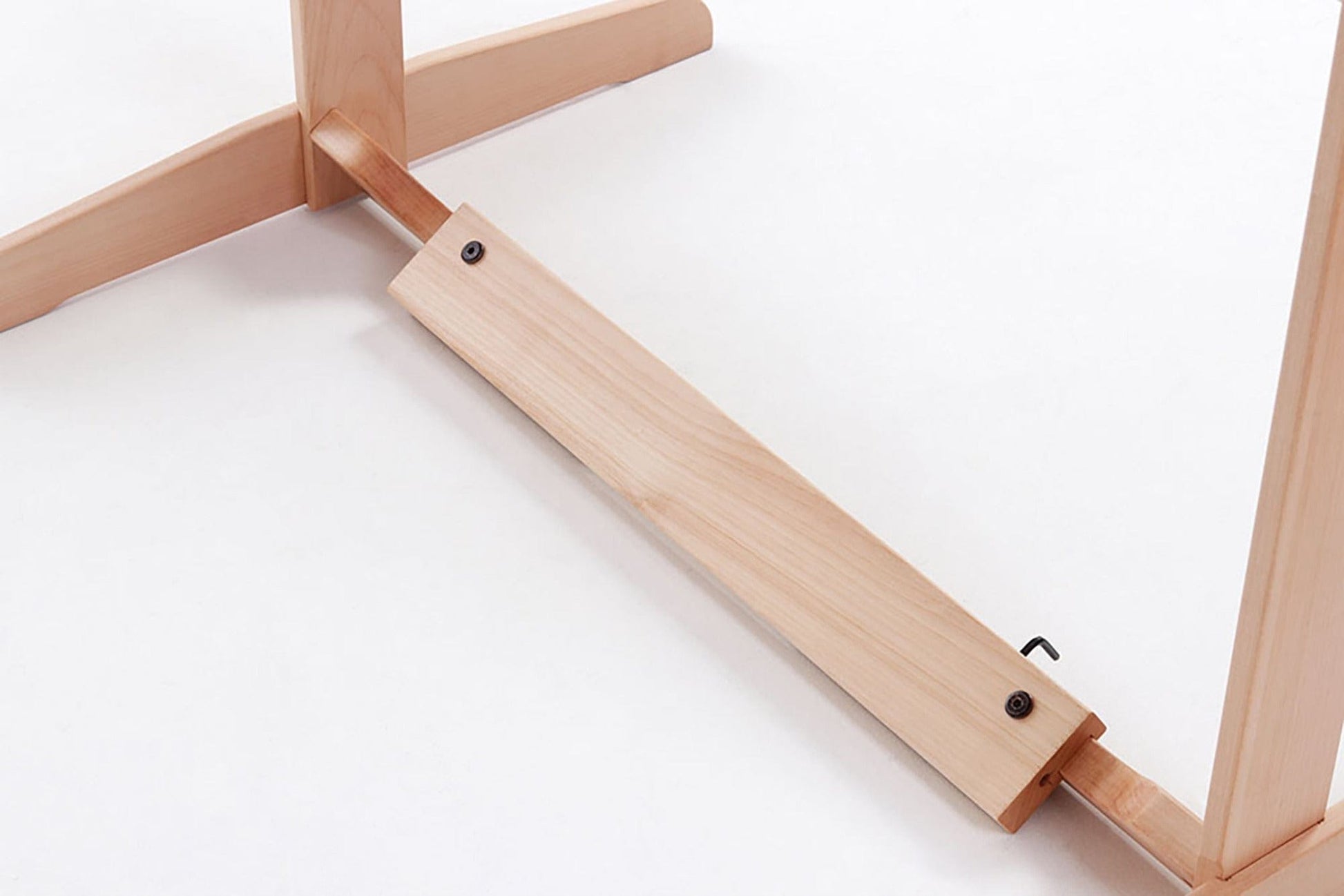 A close-up of a wooden support beam connecting the legs of the Ashford Rigid Heddle Floor Stand by Ashford Handicrafts Limited, secured with screws and a small metal hook, on a white background.