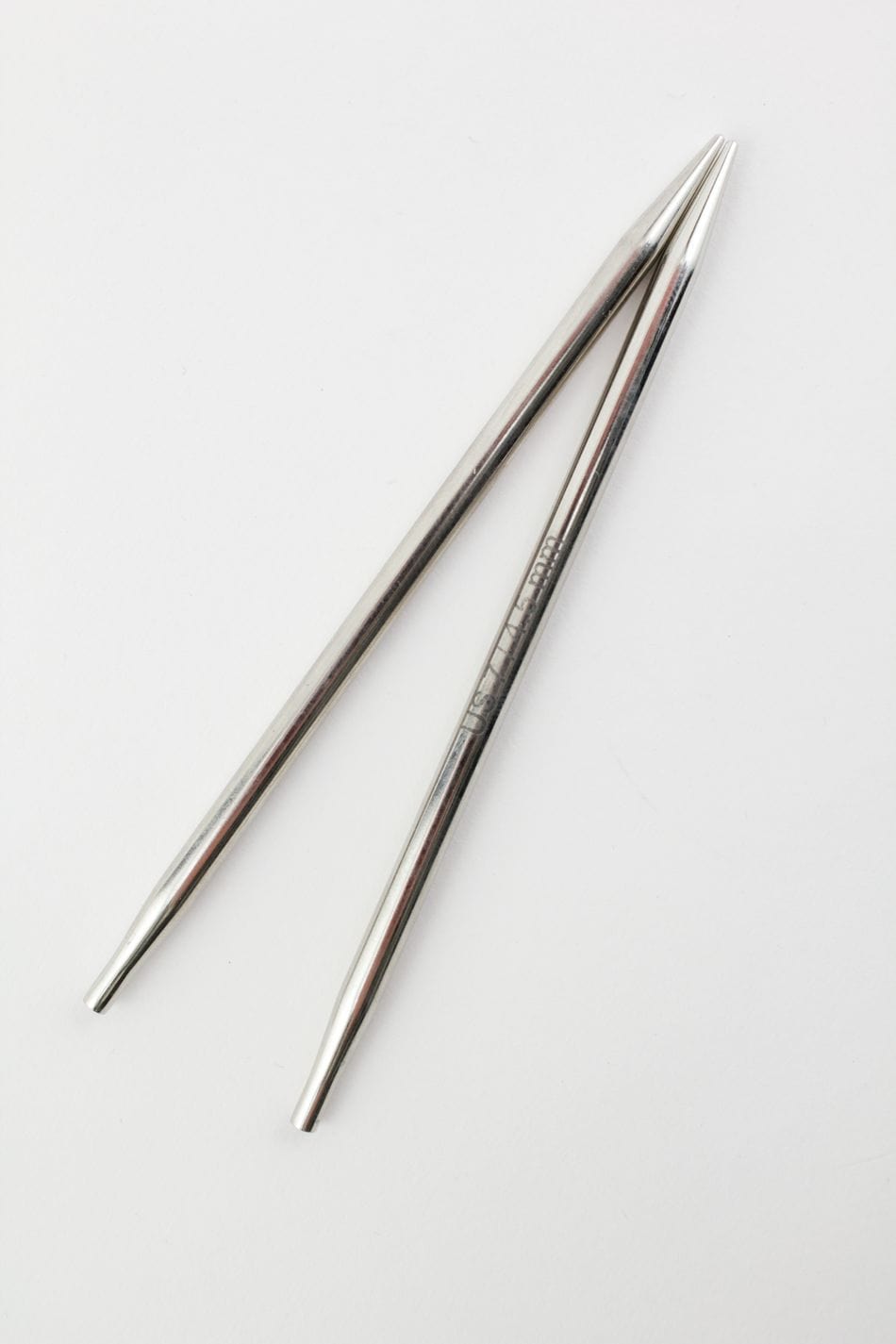 Two Knit Pro (Knitters Pride) Nova Metal Interchangeable Knitting Needles, 5" by Accessories Unlimited are crossed against a white background.