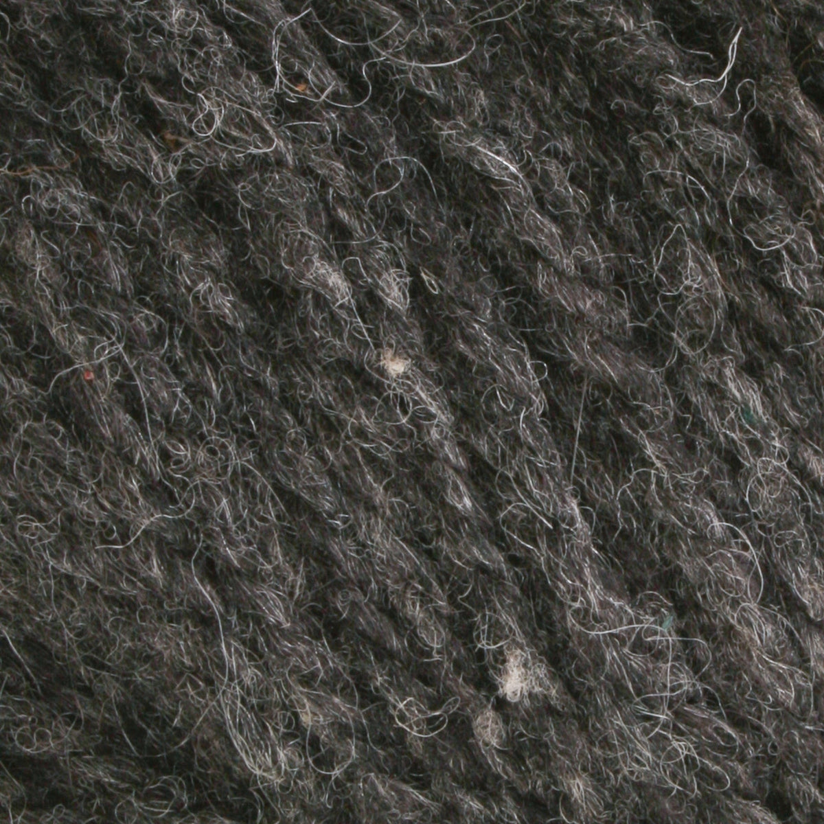 Close-up of Bartlettyarns Maine Wool Yarn (Fisherman 2-Ply) in dark gray, showing detailed fibers and texture with intertwined lighter and darker strands.