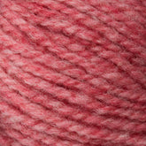 A close-up of Bartlettyarns' Bartlett Maine Wool, Sport Weight Cones features soft, thick yarn in a variegated pattern of light to medium pink. The yarn appears fuzzy and cozy, displaying a homespun texture suggesting it is made of wool.