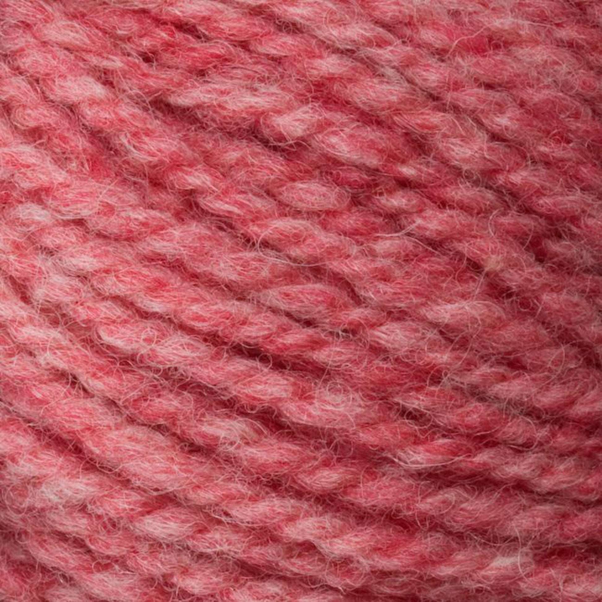 A close-up of Bartlettyarns' Bartlett Maine Wool, Sport Weight Cones features soft, thick yarn in a variegated pattern of light to medium pink. The yarn appears fuzzy and cozy, displaying a homespun texture suggesting it is made of wool.
