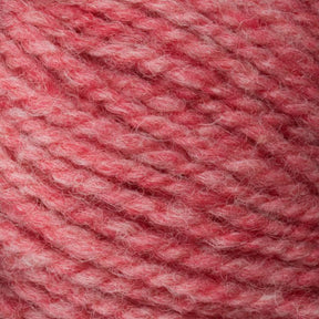 A close-up of Bartlettyarns' Bartlett Maine Wool, Sport Weight Cones features soft, thick yarn in a variegated pattern of light to medium pink. The yarn appears fuzzy and cozy, displaying a homespun texture suggesting it is made of wool.