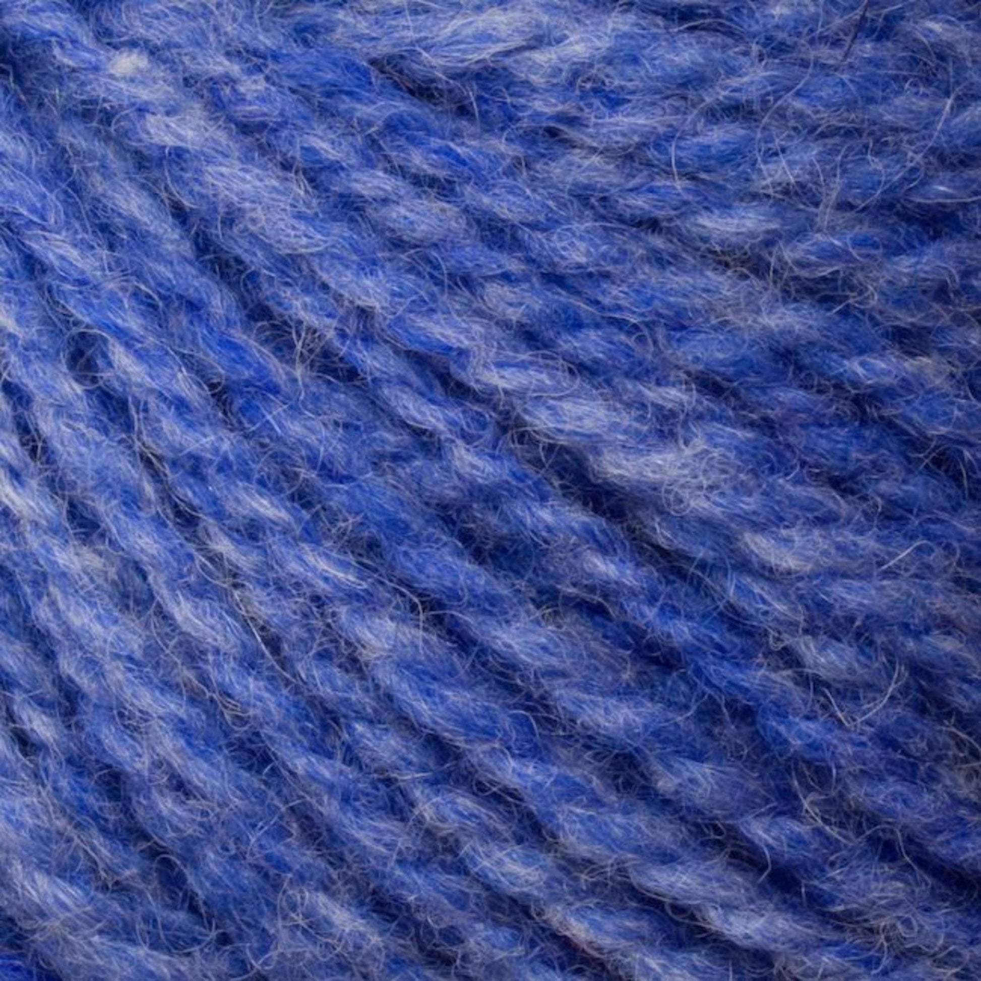 Close-up of Bartlettyarns' Bartlett Maine Wool, Sport Weight Cones in blue and purple, highlighting its soft texture and twisted strands. The subtle gradient of colors creates a cozy, homespun effect.