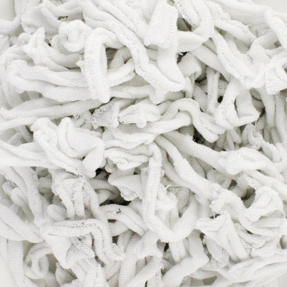 A stack of Harrisville Potholder Loops - Traditional Size, from Friendly Loom, intertwined and layered like a potholder loom creation, results in a textured and soft appearance.