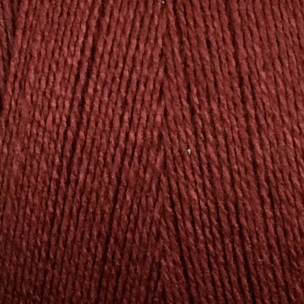 Close-up of Maurice Brassard 8/2 Tencel Yarn | Mini-cone in dark red, featuring tightly wound, smooth, and slightly shiny cellulose fibers—ideal for detailed weaving projects.