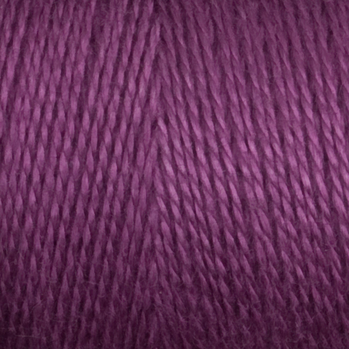 Close-up of tightly wound, purple 8/2 Tencel Yarn | Mini-cone by Maurice Brassard, highlighting its smooth texture and detailed strands—ideal for weaving projects.
