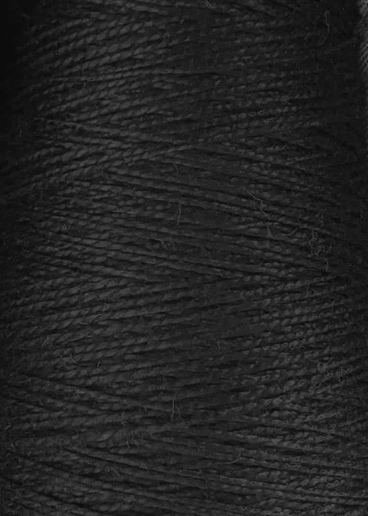 Close-up of tightly wound black Circulo 5/2 Looma Mercerized Pearl Cotton Yarn on a mini cone, showcasing the detailed texture and pattern of the fibers—an excellent choice for weaving yarn enthusiasts.