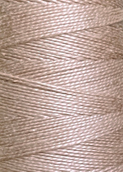 Close-up of beige or light tan Circulo 5/2 Looma Mercerized Pearl Cotton Yarn wound tightly in diagonal layers on a large cone, highlighting the texture and fibers of this premium material.