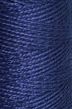 Close-up of tightly wound dark blue 10/2 Looma Circulo Mercerized Pearl Cotton Yarn | Mini Cone, showcasing the texture and individual strands reflecting light—a sheen reminiscent of premium Oeko-Tex certified fibers.