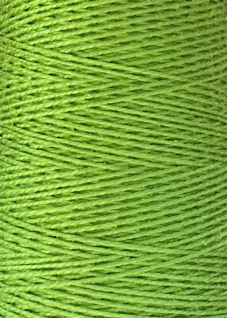 Close-up of tightly wound green threads reveals the rich texture and diagonal pattern of the detailed strands. This is Circulo’s 3/2 Looma Circulo Mercerized Pearl Cotton Yarn | Mini Cone, high-quality cotton weaving yarn that is Oeko-Tex certified for safety and sustainability.