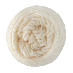 A close-up of a thick, cream-colored Brown Sheep Lambs Pride Worsted Yarn ball with mohair, coiled in a spiral and displayed against a white background.