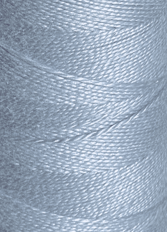 Close-up of a spool of shiny, light blue 5/2 Looma Circulo Mercerized Pearl Cotton Yarn wound tightly in overlapping layers, highlighting the fiber texture and sheen—ideal for weaving projects or as premium yarn from Circulo's mini cone collection.