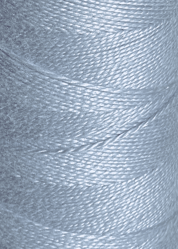 Close-up of a spool of Circulo 3/2 Looma Mercerized Pearl Cotton Yarn | Mini Cone in shiny, light blue, tightly wound to showcase the texture and sheen of the individual fibers.
