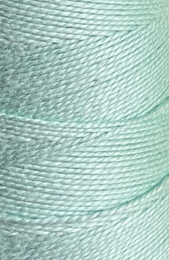 Close-up image of Circulo 10/2 Looma Mercerized Pearl Cotton Yarn in light blue-green, wound tightly on a mini cone. The smooth, lustrous fibers are clearly visible, highlighting the detailed texture and intricate overlapping pattern of this premium Circulo weaving yarn.