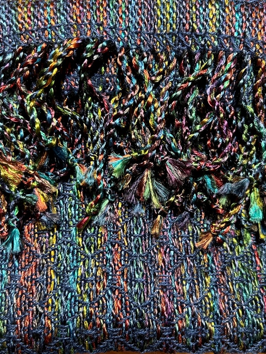 Close-up of vibrant handwoven scarves in blue, green, orange, and yellow, featured at the Halcyon Yarn Weaving Demo + Pop-Up Shop to benefit Oasis Free Clinic, Friday & Saturday May 8th & 9th (all day).