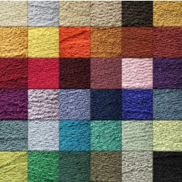A grid of textured swatches in various colors, including shades of yellow, orange, red, pink, purple, blue, green, and brown. Each square has a distinct, uneven surface, creating a variety of visual and tactile effects.