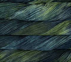 A skein of Malabrigo Sock fingering weight yarn in variegated tones of dark green, teal, and charcoal.