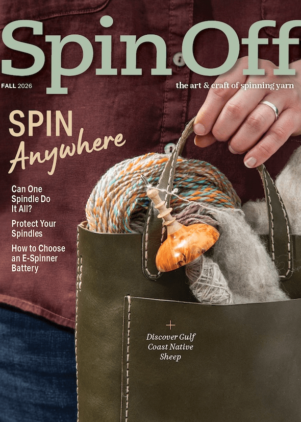 A person holds a green tote bag filled with yarn, fiber, and a wooden spindle—ideal for spinning wherever you are. The cover of Spin Off Fall 2026 by Long Thread Media is visible, featuring headlines about spinning yarn and highlighting portable spinning tools and the delights of fiber arts.