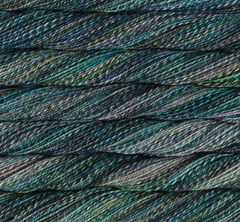 Close-up of a hand-dyed Malabrigo Torzal skein in sport weight, featuring a variegated blend of dark teal, forest green, grey, and black.
