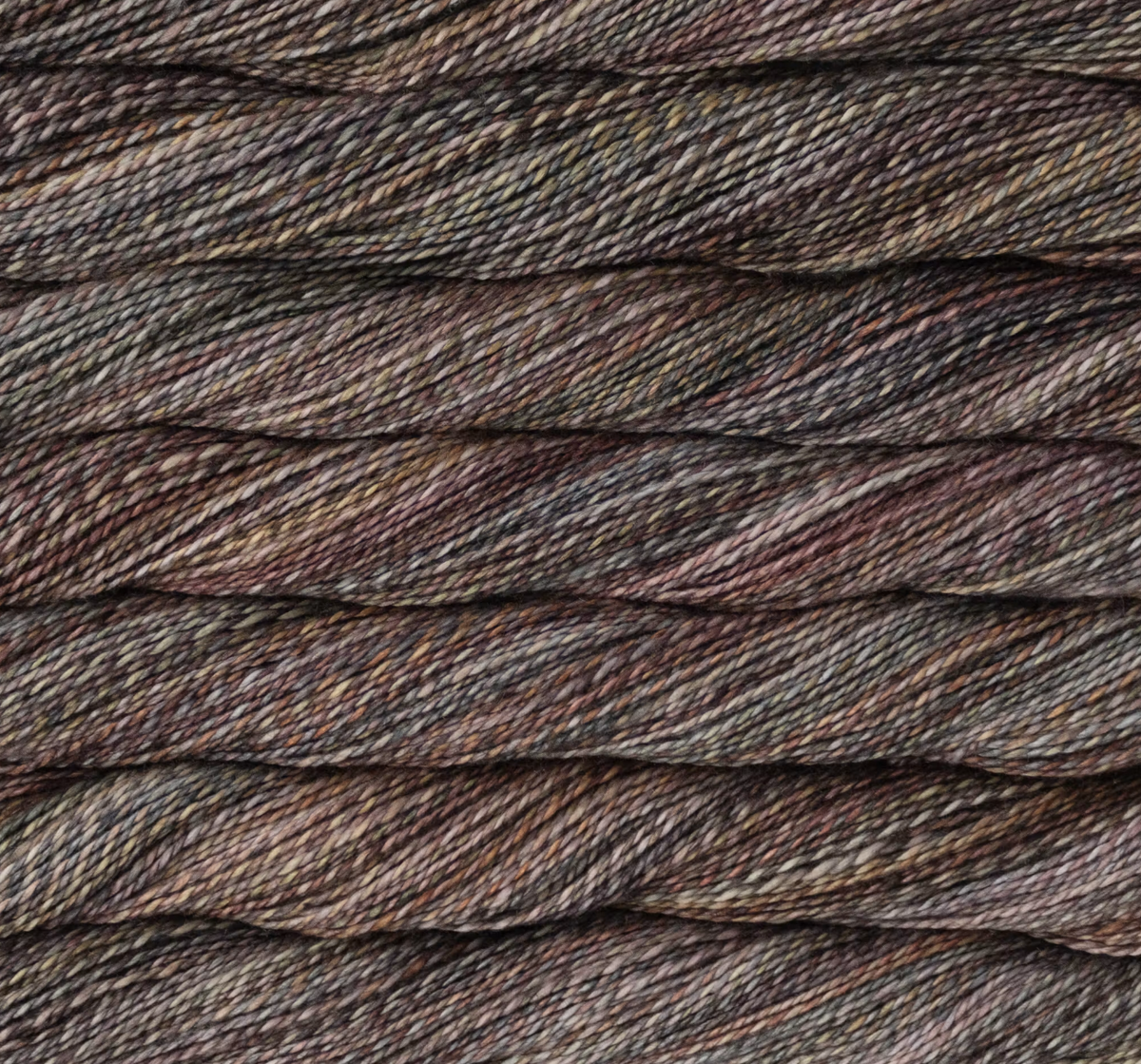 Close-up view of twisted, sport weight Malabrigo Torzal hand-dyed yarn in shades of grey, brown, and tan.