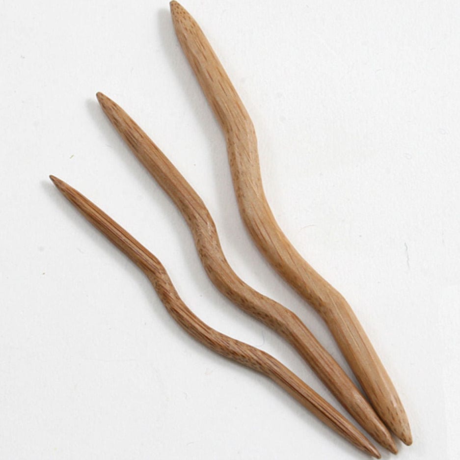 Three N. Jefferson Bamboo Cable Stitch Holders with a natural wavy design and pointed ends are arranged on a white background, varying in size—ideal companions to your favorite knitting accessories.