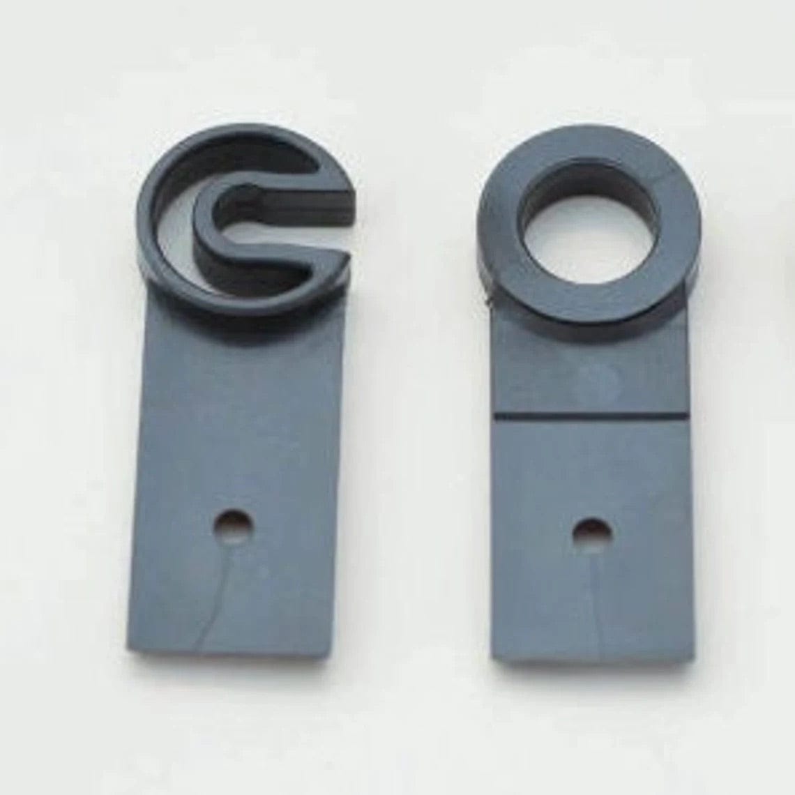 Two flat, rectangular, dark gray plastic pieces—one C-shaped and one O-shaped—each with a hole near the bottom. Ashford Maiden Bearing Replacement by Ashford Handicrafts Limited for your spinning wheel.