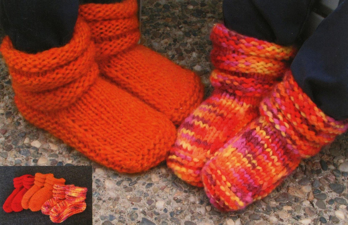 Two people wear Bryson Distributing, Inc. Children’s Mukluk Slippers #113—one solid orange, one multicolored—while more cozy pairs sit on a dark surface, perfect for keeping feet warm.