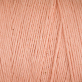 Close-up of soft, pale pink Cotton Carpet Warp 8/4 yarn with a uniform pattern. The colorfast texture features smooth strands and slight hue variations, offering a subtle, natural look similar to cotton warp yarn used for crafting rag rugs.