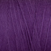 A close-up of the Cotton Carpet Warp 8/4 reveals soft, purple fibers resembling wool, weaving together like rag rugs to form a dense, fuzzy texture.
