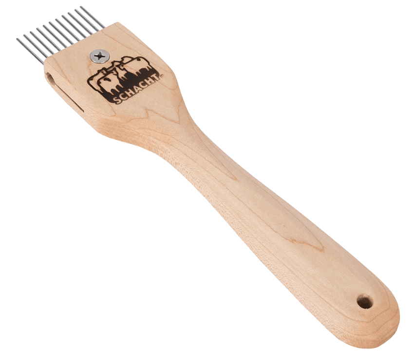 A wooden handle weaving tool with six metal prongs, used for weaving. The handle has a Schacht logo and a hole at the end for hanging. This Duet beater also features interchangeable metal combs, making it versatile for a range of weaving projects.