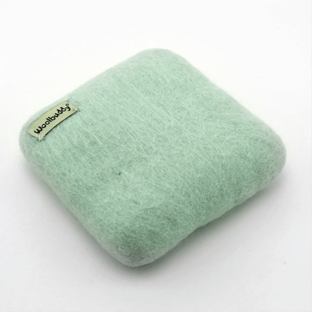 The Woolbuddy Felting Mat, Small is a light green, square 100% wool mat with rounded edges and a woolbuddy tag—ideal for needle felting projects. Shown on a plain white background. Brand: Woolbuddy.