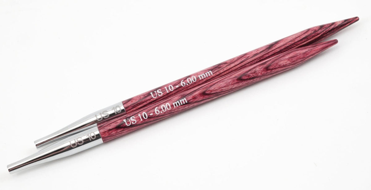 Two Accessories Unlimited Knit Pro (Knitters Pride) Dreamz Interchangeable Knitting Needle Tips, size US 10 (6.00 mm), with reddish-purple laminated birch and metal bases, display distinct grain patterns against a white background.