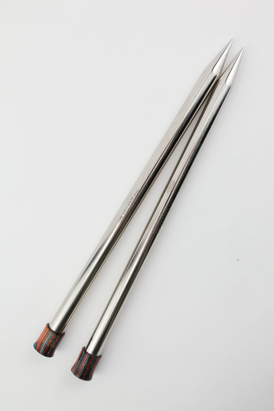 Two Knit Pro (Knitters Pride) Nova Metal Single Point Knitting Needles, 10" or 14", by Accessories Unlimited, with pointed tips and wooden ends, are placed parallel on a white surface.