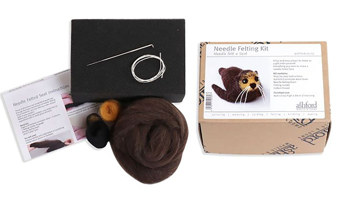 The Ashford Needle Felting Kit by Ashford Handicrafts Limited includes felting needles, a foam pad, brown and black wool, step-by-step instructions, and a box featuring the finished seal—ideal for your next needle felting project.