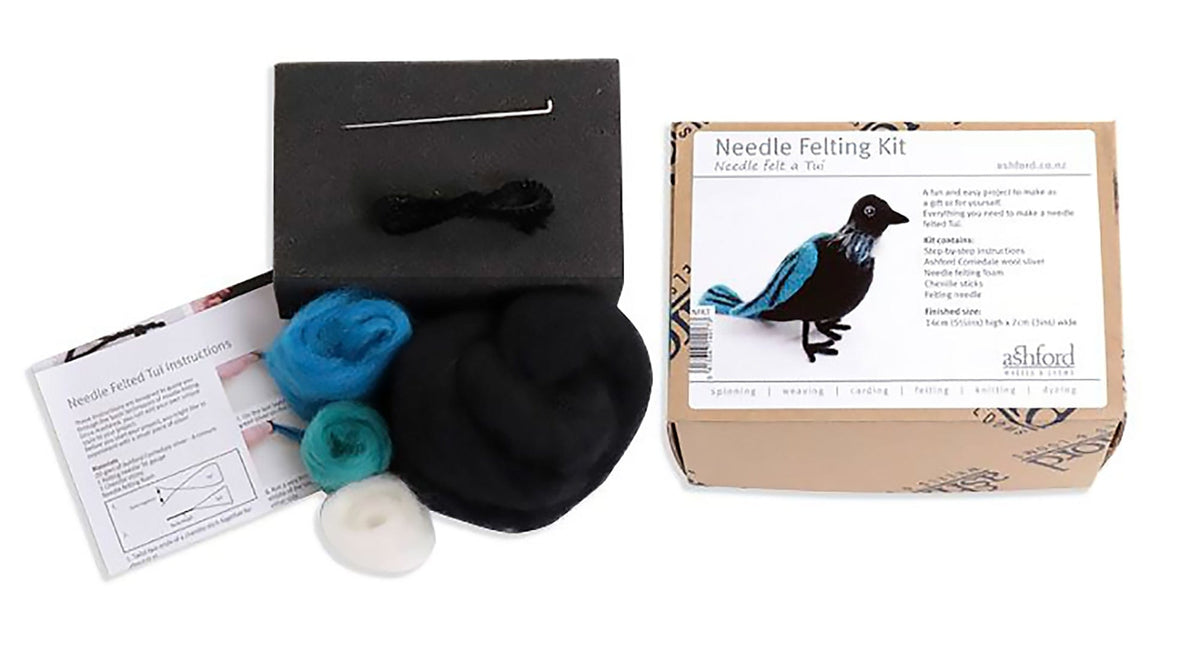 The Ashford Needle Felting Kit by Ashford Handicrafts Limited includes black, blue, teal, and white wool, a needle, black thread, clear instructions, and a box with a felted bird image—ideal for your next felting project.
