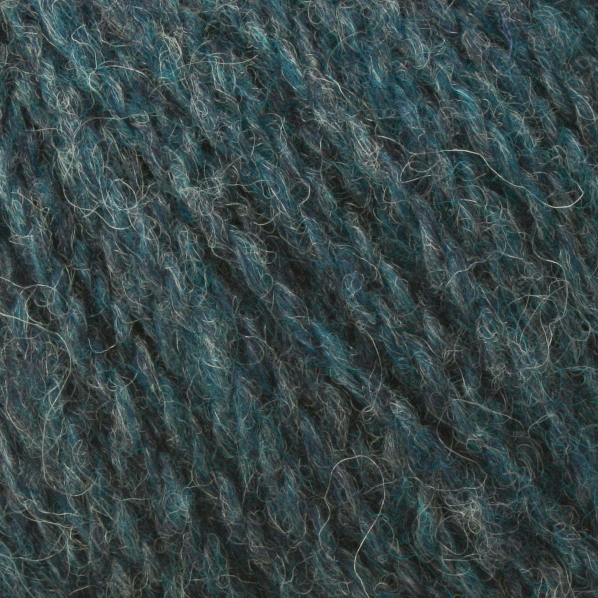 Close-up of Bartlettyarns Maine Wool Yarn (Fisherman 2-Ply) by Bartlettyarns, featuring dark blue and teal fibers with a soft, fuzzy texture and subtle variations in color and thickness throughout the strands.