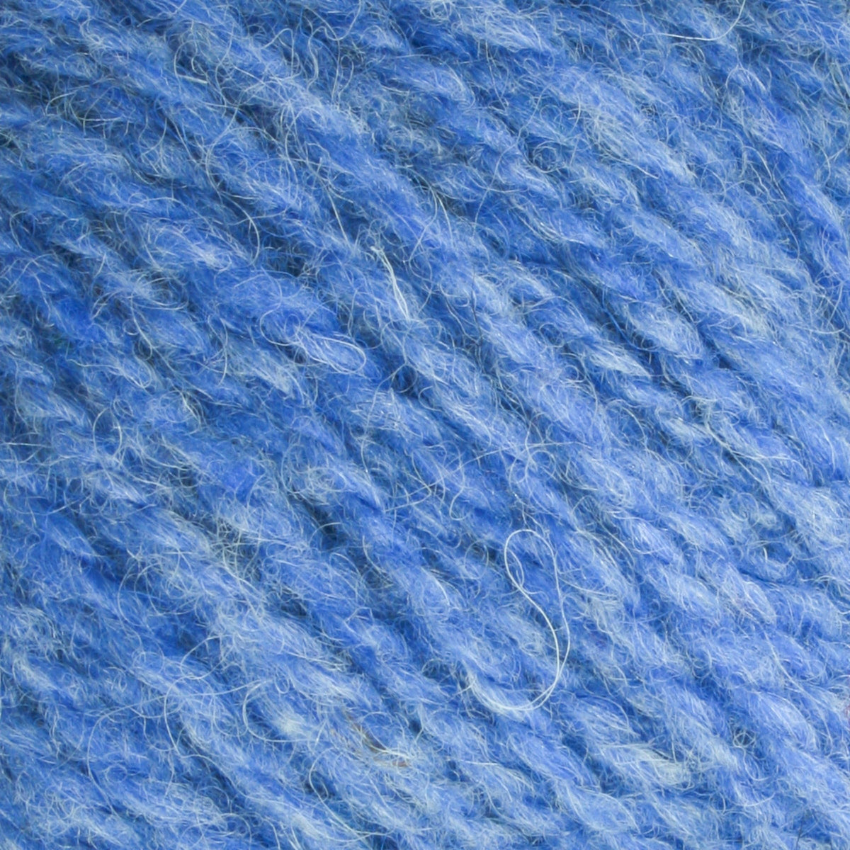 Close-up of Bartlettyarns Maine Wool Yarn (Fisherman 2-Ply) by Bartlettyarns, highlighting soft, fuzzy texture, twisted fibers, detailed strands, subtle blue shade variations, and the classic worsted weight yarn appearance.