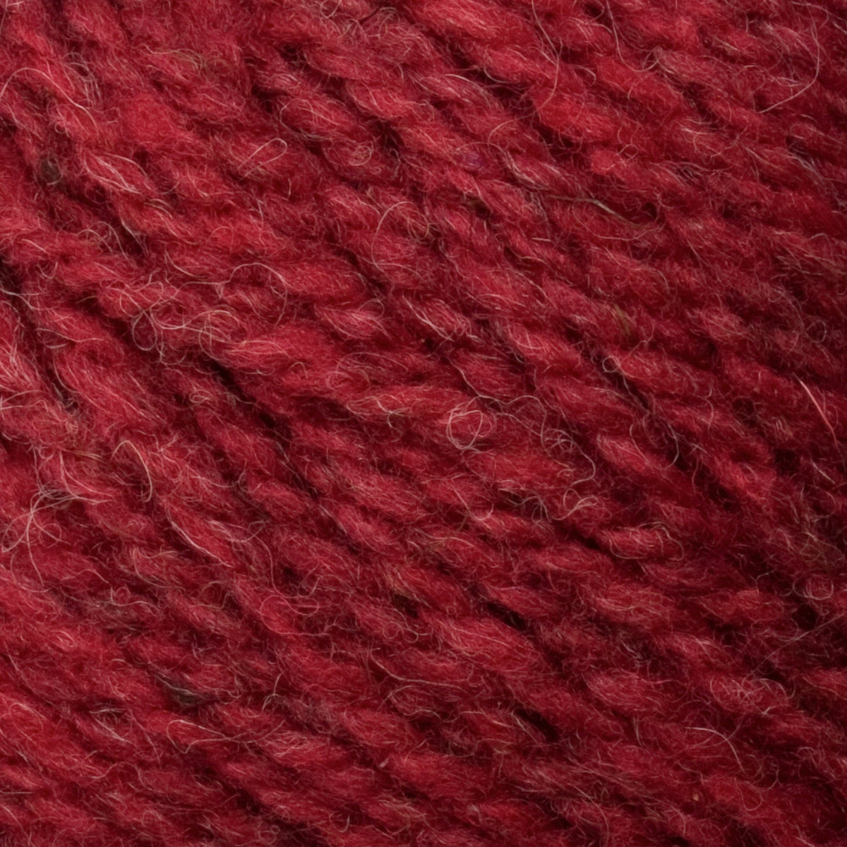 Close-up of Bartlettyarns Maine Wool Yarn (Fisherman 2-Ply) by Bartlettyarns, revealing the deep red worsted weight yarn's twisted fiber texture and subtle color variations.