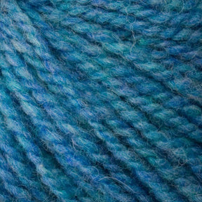 Close-up of the intricately twisted blue and teal fibers of Bartlettyarns' Bartlett Maine Wool, Sport Weight Cones, creating a textured pattern with hints of green that enhances its homespun charm.