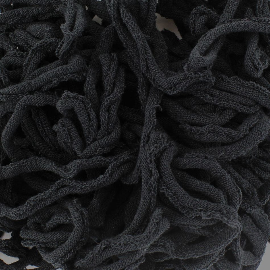 Close-up of a tangled pile of Harrisville Potholder Loops - Traditional Size by Friendly Loom, resembling black fabric strands crafted into intricate patterns on a traditional loom, creating a textured and chaotic design.