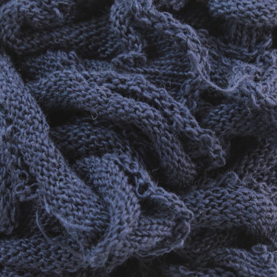 Close-up of a textured, dark blue fabric from Harrisville Potholder Loops in the Traditional Size by Friendly Loom, featuring a knitted design with loosely woven strands creating an intricate pattern reminiscent of classic loom craftsmanship.