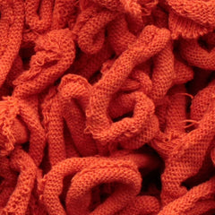Close-up of the Harrisville Potholder Loops - Traditional Size by Friendly Loom, featuring a textured surface composed of intertwined, looped strands of vibrant orange fabric that resemble intricate patterns from a traditional loom, resulting in a dense and tangled appearance.