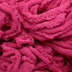 A close-up of a tangled pile of Harrisville Potholder Loops - Traditional Size in a bright pink hue, from Friendly Loom, resembling the intricate weave you'd find on a traditional loom, showcasing its wavy texture and soft, fibrous appearance.