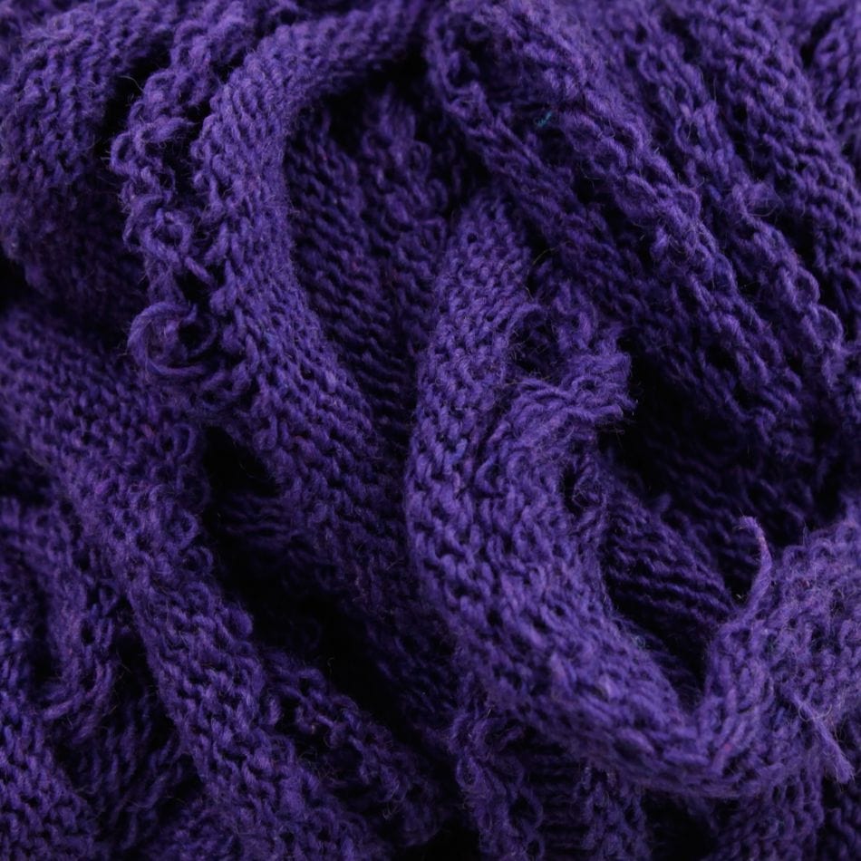 Close-up of a textured mass of Harrisville Potholder Loops by Friendly Loom, showcasing intricate knit patterns and folds reminiscent of a traditional loom. The loops appear soft and thick, with varying shades of deep purple creating a rich, tactile surface.